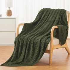 a green blanket sitting on top of a wooden chair