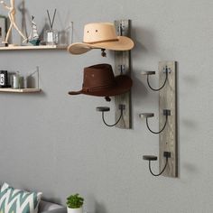 two hats are hanging on the wall next to hooks and hat racks in a living room