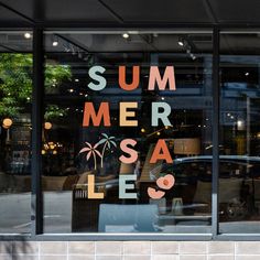 a store window with the words summer sale written on it's glass and palm trees in the reflection