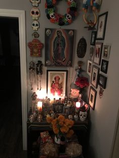 a room with pictures, candles and skulls on the wall