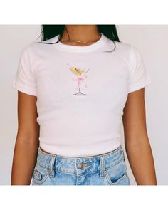 Martini Baby Tee   Women's T-Shirt | Girly Aesthetic | Y2K Trendy Shirt 🌟SHIRT This is a Bella+Canvas baby tee - the material is very soft and very high quality. 🌟SIZING Please find the size chart in listing photo before purchasing. We recommended measuring a t-shirt you already own to get the best fitting t-shirt. 💖CARE/ WASH Machine wash: warm (max 40C or 105F); Non-chlorine: bleach as needed Tumble dry: medium heat; Iron, steam or dry: low heat; Do not dry clean. ✨SHIPPING Your items usual Fitted Basic T-shirt With Funny Print, Cute Fitted Summer T-shirt, Cute White Short Sleeve Crop Top, Cute Short Sleeve Tops With Funny Print, Fitted Pink Graphic Tee Shirt, Cute Fitted Shirt With Graphic Print, Fitted Cute Shirt With Graphic Print, Pink Fitted Graphic Tee, Cute Fitted Cotton Shirt