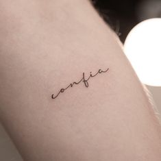 the word confira written in cursive handwriting on someone's arm