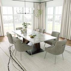 a dining room table with chairs and a rug on the floor in front of large windows