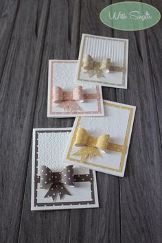 some cards with bows on them sitting on a table