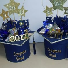 two graduation hats with gold and blue decorations in them, one is for congrats grad