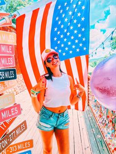 a woman holding an american flag in front of a street sign