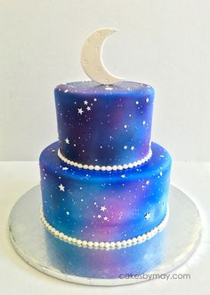 a three tiered cake decorated with stars and the moon