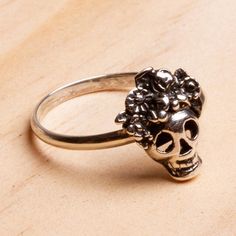 With flowers atop her skull Catrina is gorgeous. Oscar Figueroa Escorcia creates this excellent cocktail ring from gleaming Taxco sterling silver with oxidation enhancing the details. The skull tops a slender sterling band.The original La Calavera Catrina was a zinc etching created by the artist Jose Guadalupe Posada in Mexico around 1910. Posada created the character a female skeleton with an elegant hat as a satirical portrait of Mexican natives who aspired to European style and denied their o Catrina Costume Jewelry, Adjustable Stamped 925 Skull Ring As Gift, Adjustable 925 Stamped Skull Ring For Gift, Nickel-free Skull Jewelry For Day Of The Dead, Nickel Free Skull Jewelry For Day Of The Dead, Adjustable Silver Skull Ring Nickel Free, Adjustable Vintage Skull Ring Gift, Adjustable Nickel-free Silver Skull Ring, Bohemian Sterling Silver Skull Jewelry