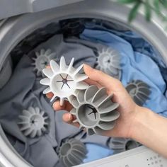 someone is holding some type of object in front of the washer's door