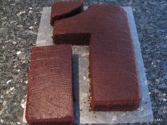 chocolate cake sitting on top of a piece of parchment paper with one slice cut out