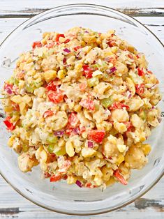 a bowl filled with pasta salad on top of a wooden table