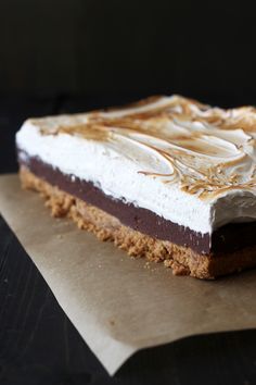 a piece of cake sitting on top of a piece of wax paper with icing