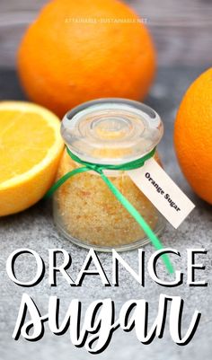 orange sugar in a glass jar next to two oranges and an empty tag on the label