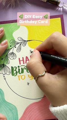 a woman is writing on a birthday card