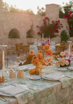 the table is set with flowers, candles and wine glasses for an elegant dinner party