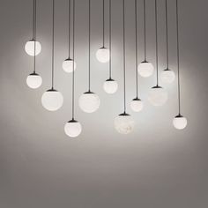 a bunch of lights that are hanging from the ceiling in a room with white walls