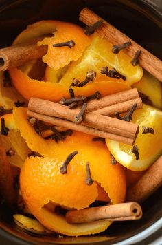 oranges and cinnamon sticks are in an instant pot with spices on the side for garnish