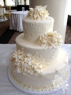 a three tiered white wedding cake on a table