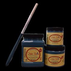 three jars of blue paint with a wooden stick