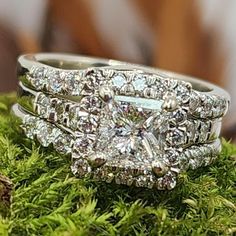 two wedding rings sitting on top of green moss