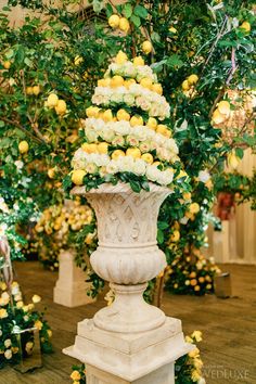 a large white vase filled with lots of lemons