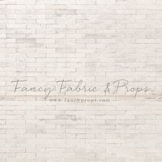 a white brick wall with the words fancy fabric and pops on it in cursive writing