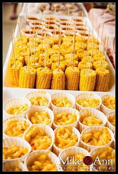 corn on the cob and cupcakes are arranged in paper cups for display