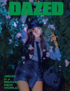 the cover of dazed magazine featuring a young woman wearing a hat and tie sitting in front of flowers