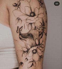 a woman's arm with flowers and a fox tattoo on the left side of her arm