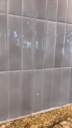 a close up of a white tile wall in a kitchen