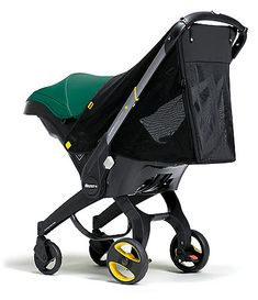 a baby stroller with a green seat and black mesh cover on the front wheel