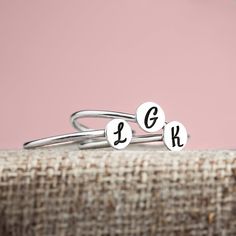 Wrap your fingers in the timeless elegance and personal charm of our Set of 3 Signet Initial Stacking Rings. Imagine carrying the your loved ones' initials right at your fingertips - a gentle reminder of life's blessings and the love that surrounds you. Each delicately engraved round disc can be personalized with an initial, forging a bond with those who fill your heart with joy - be it children, a spouse, or someone dear. These rings are a beautiful representation of motherhood or a symbol of t Adjustable Silver Engraved Ring With Initials, Personalized Silver Initial Open Ring, Dainty Adjustable Stackable Initials Rings, Dainty Adjustable Stackable Rings With Initials, Sterling Silver Initial Ring For Gift, Adjustable Silver Monogram Ring, Personalized Adjustable Sterling Silver Couple Rings, Personalized Adjustable White Gold Initial Ring, Dainty Adjustable Initial Ring For Anniversary