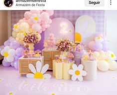 a pink and yellow birthday party with balloons, flowers, cake and desserts on the table