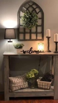 a table with a welcome sign on it and some candles in front of the table