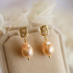 This gorgeous pair of Baroque Pearls earrings has beautiful overtones colour between metallic gold and orange. Very soft colours with own character from mother nature. The pearls have strong lustre and dangling under Moon and Star ear studs. The pictures do not do this earrings justice Let this unique piece be a perfect accessory for your everyday adventures or a gift to the loved one.  Size of pearl approx. 12X9mm. The earrings length from top to bottom is approx. 25mm. Follow me on Instagram: Elegant Apricot Earrings For Gift, Gold High Luster Earrings, High Luster Gold Earrings, Gold High Luster Pearl Earrings, Elegant Apricot Dangle Earrings, Gold Pear-shaped Earrings With High Luster, Gold Pear-shaped High Luster Earrings, Handmade Elegant Apricot Earrings, Handmade Apricot Earrings In Elegant Style