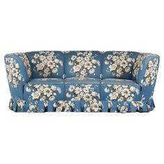 a blue floral couch with white flowers on it's arms and back, sitting in front of a white background