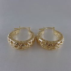 Step into the world of elegance and style with our stunning Gold Plated Filigree Hoop Earrings. Designed to make a statement, these earrings add a touch of glamour to any ensemble. Get ready to turn heads and feel fabulous!Inner diameter: 18mm - 11/16 in.Outer Diameter: 25mm - 1 in.Width at the bottom: 9mm - 3/8 in. Filigree Hoop Earrings, Gold Plate, Hoop Earrings, Plating, Floral, Gold