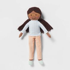 a doll with brown hair and glasses laying on a white surface next to a wall