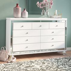 a white dresser sitting in front of a mirror