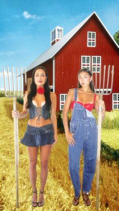 two women standing next to each other in front of a red barn holding pitchforks