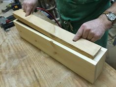 a man working with wood on a table