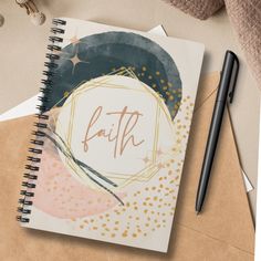 a notebook with the word faith written on it next to a pen and envelopes