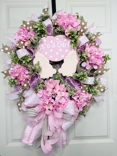 a pink wreath with it's a girl written on the front and back side