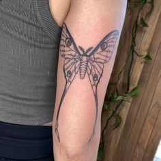 a woman's arm with a butterfly tattoo on the left side of her body