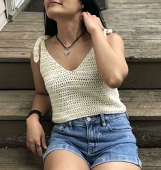 a woman is sitting on the steps with her hand under her ear and looking up