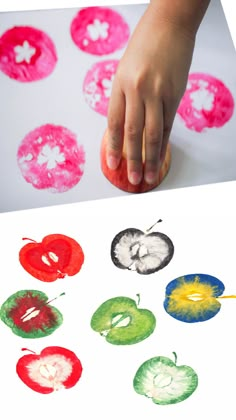 a child's hand on top of a piece of paper with different colored circles