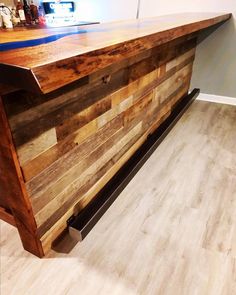 a bar made out of wooden planks in a room with hard wood flooring