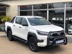 a white toyota pickup truck parked in front of a building