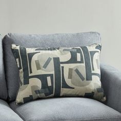 a gray couch with a black and white pillow on it