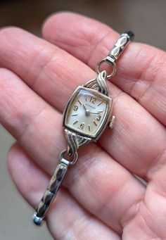 This is a beautiful Wittnauer ladies watch that is currently working! I am not a watch expert, nor have I had it tested or serviced, it is being sold AS IS. I've wound it several times and it keeps fairly good time, not perfect, but ok.  I would strongly recommend having it serviced by a professional. The square face has a pearly white face with silver hands and numerals. The watch screams DECO! I love the swirl detail on the top and bottom. This watch would best fit a 6.5" or smaller. It does have a gorgeous segmented stretch band for additional comfort. The watch is marked 10k RGP and the band 10k gold filled. Given the age of the watches there will be scuffs and scratches, I do my best to highlight them in the pics and detail them in the description so there are no unpleasant surprises Whimsigoth Wedding, Square Face, Stretch Band, Square Faces, Stretch Bands, White Face, Women Wrist Watch, Steampunk Fashion, Ladies Watch